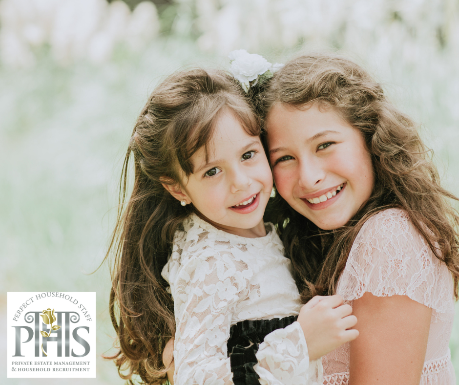 Two smiling sisters playing together, symbolising sibling harmony and positive bonding.